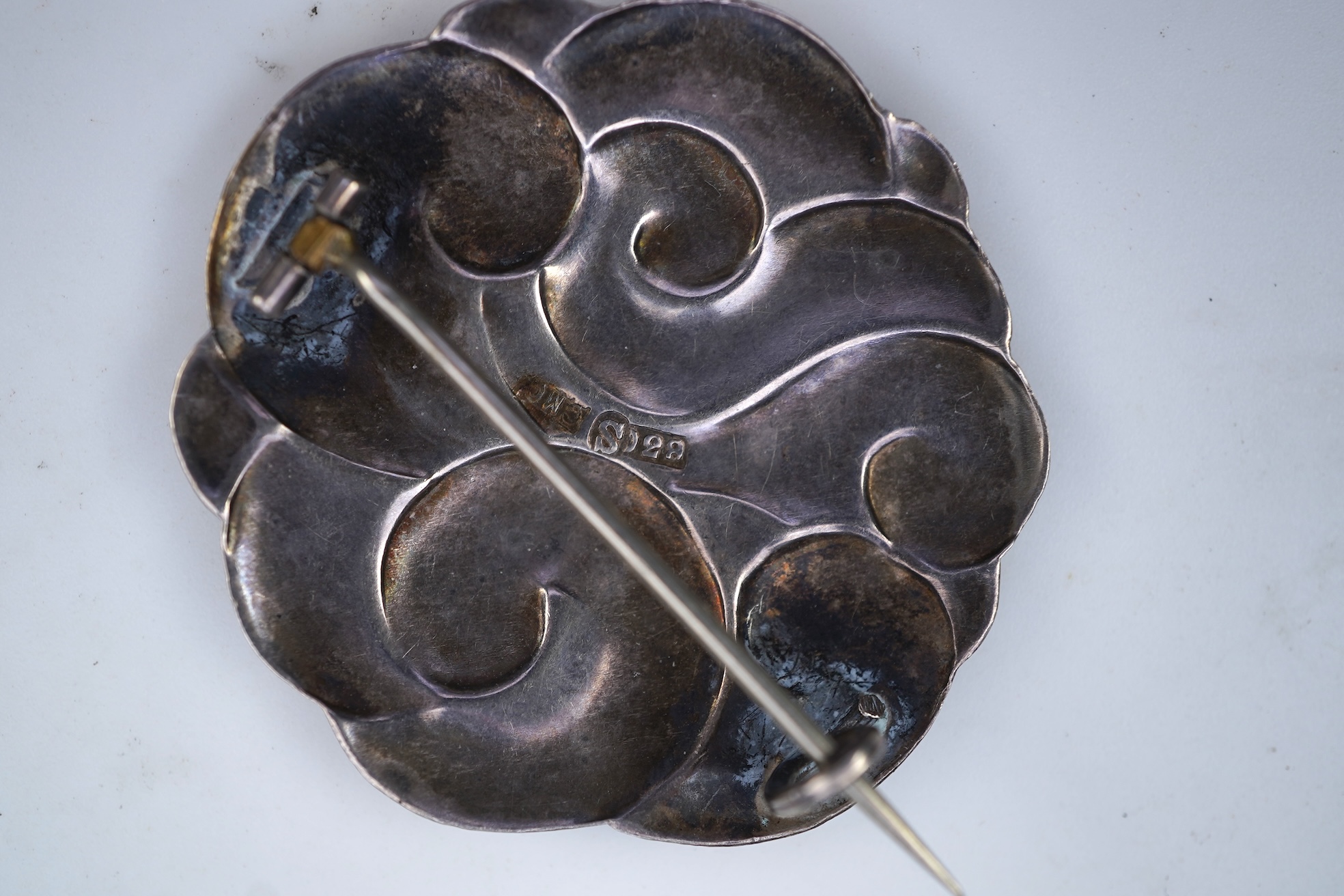 An Arts & Crafts silver slide and three silver brooches, probably Denmark, first half 20th century